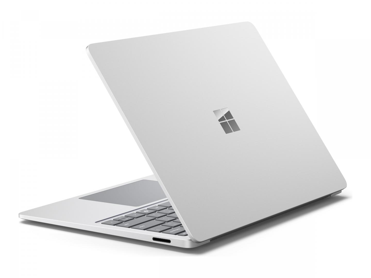 Ein silberner Laptop mit geöffnetem Bildschirm und Tastatur, mit Microsoft-Logo.
