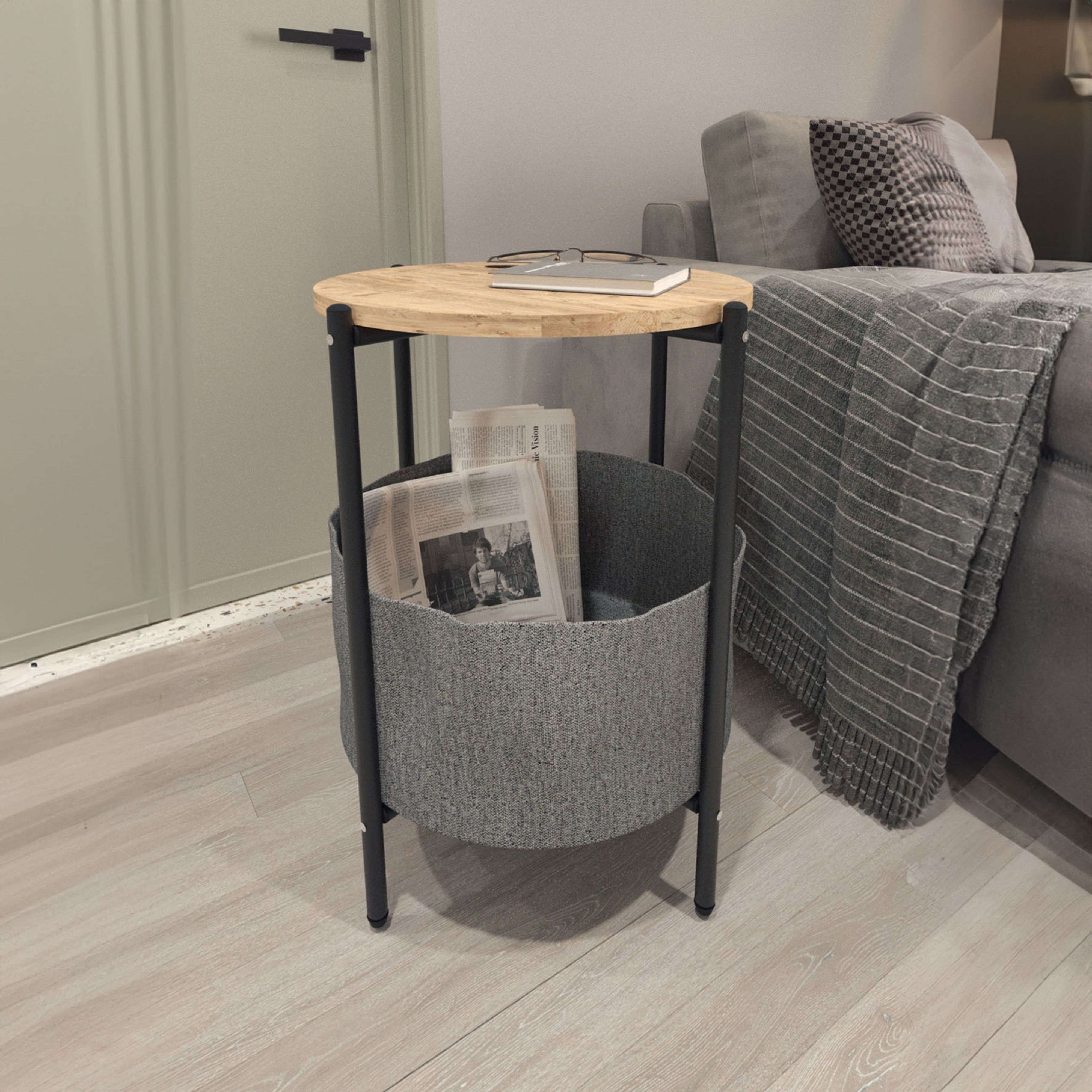Una mesa redonda de madera con periódicos y gafas se sienta junto a un sofá gris.