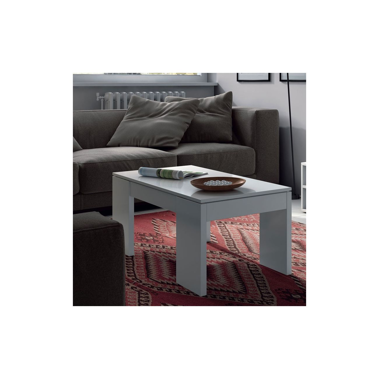 Una mesa de centro gris moderna con revista y cuenco sobre una alfombra.