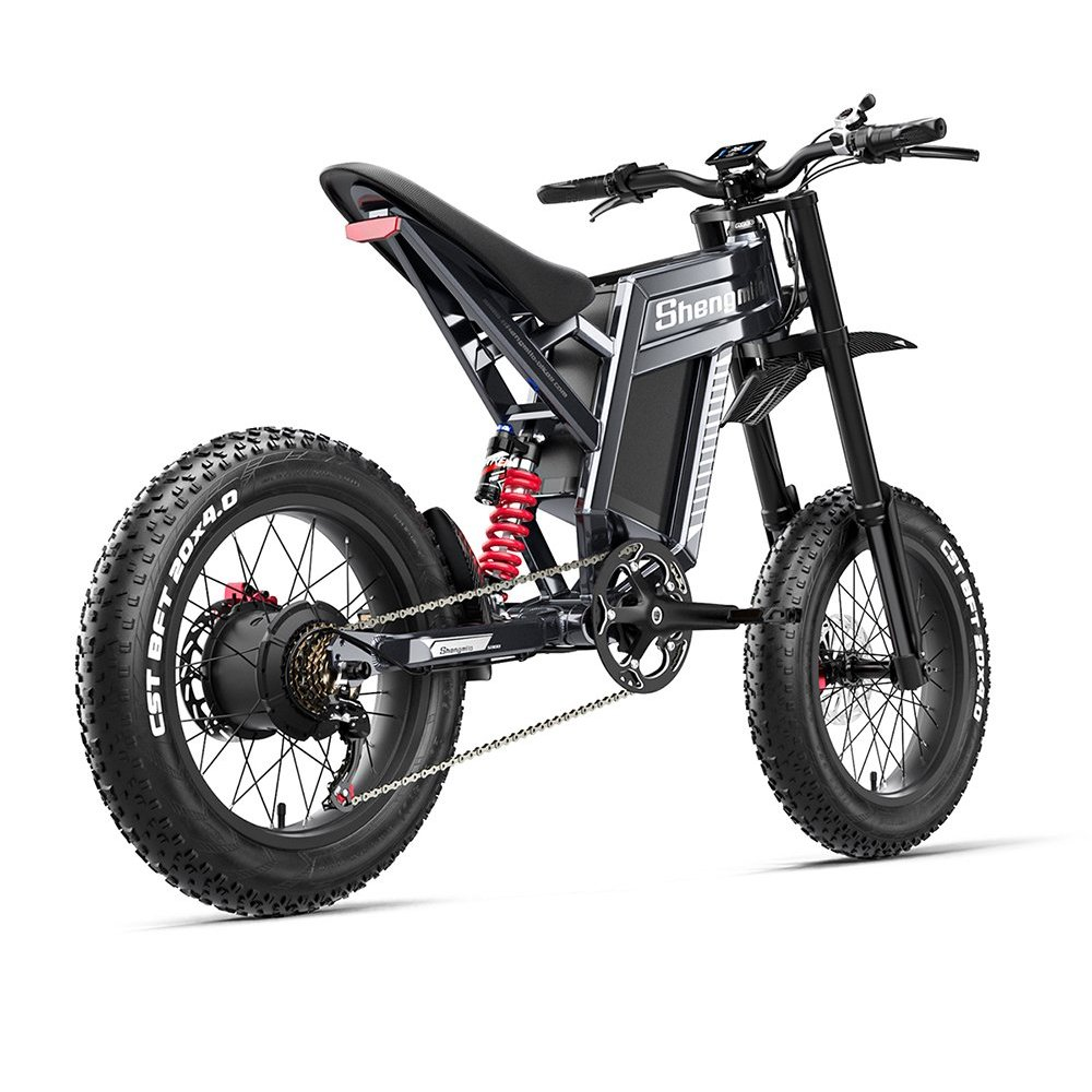 Bicicleta eléctrica negra con neumáticos anchos, amortiguadores rojos y detalles plateados.