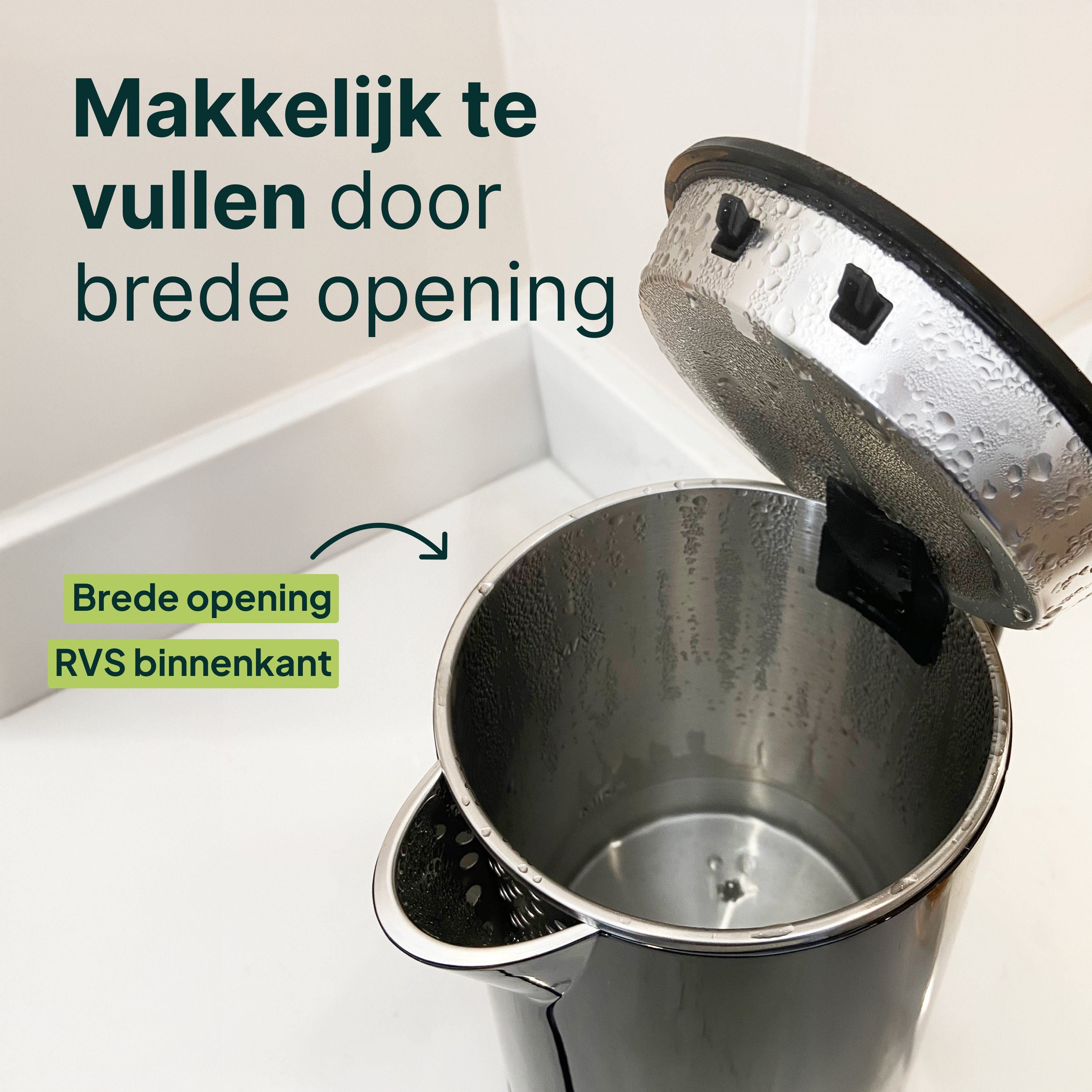 Een open zwarte waterkoker met waterdruppels op het deksel en binnenin.
