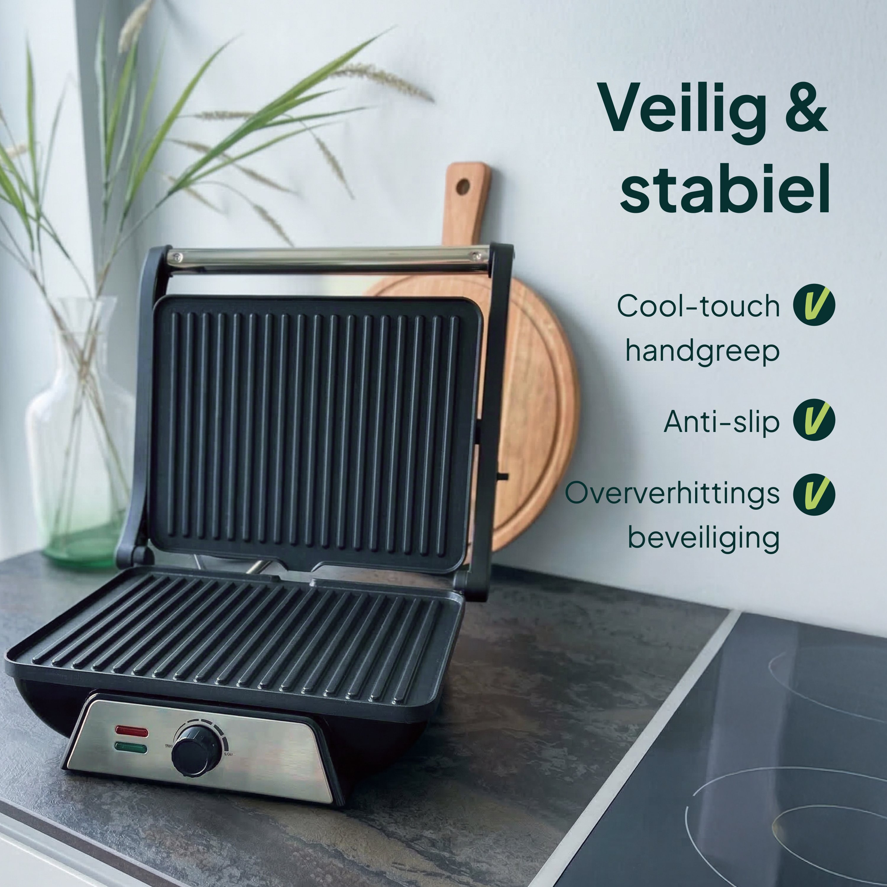 An open contact grill with a metal handle on a dark countertop.
