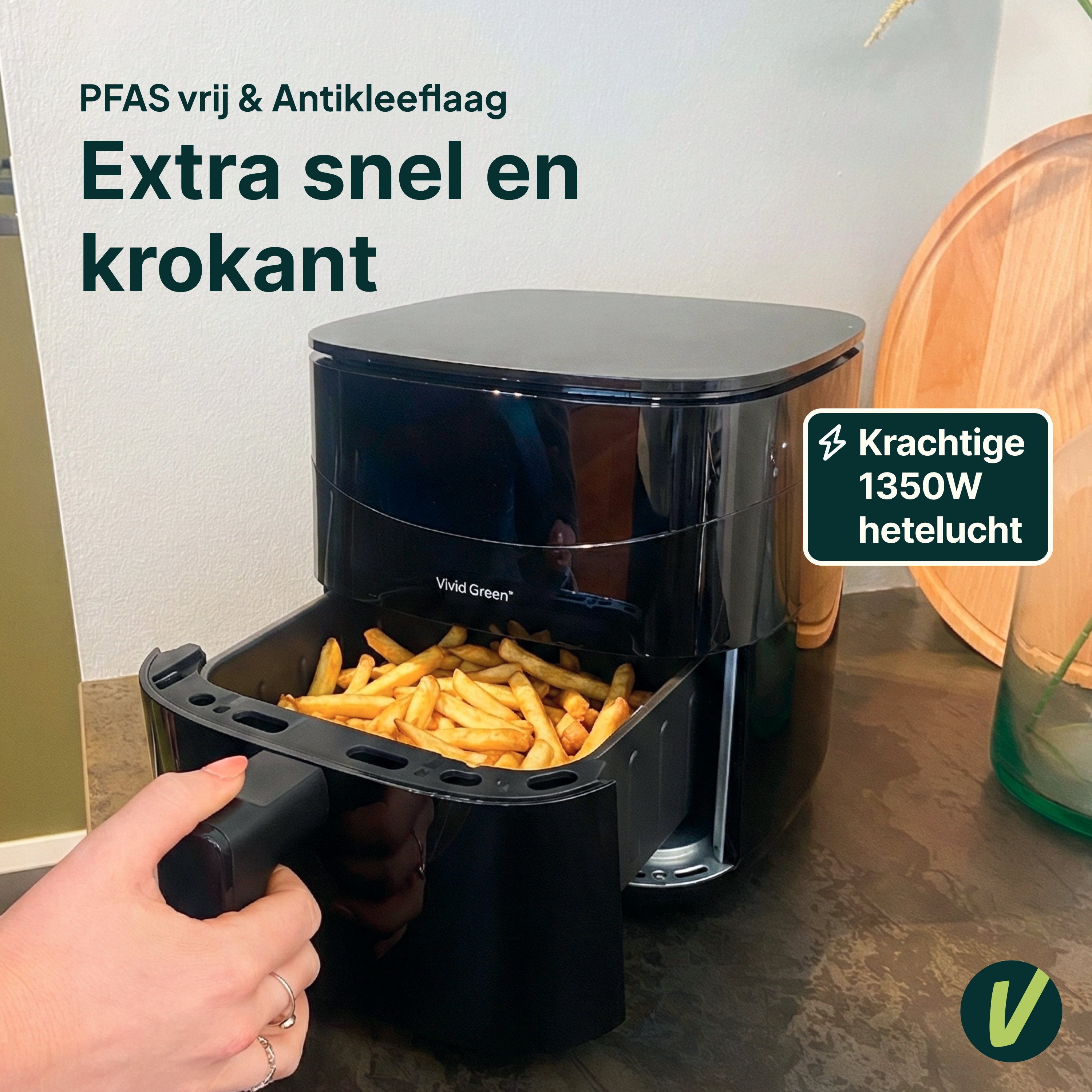 A black air fryer filled with french fries sits on a counter top.
