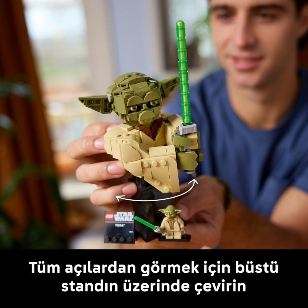 Un uomo tiene una figura Lego di Yoda con spada laser, che ruota su un supporto.