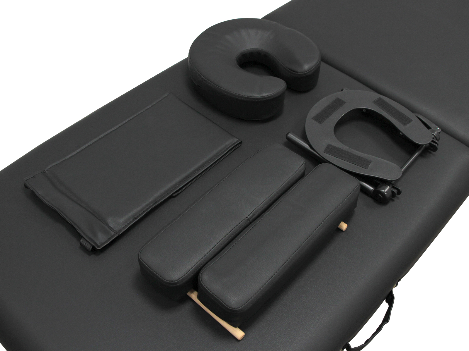 Mesa de masaje negra con reposacabezas, reposabrazos y accesorios.