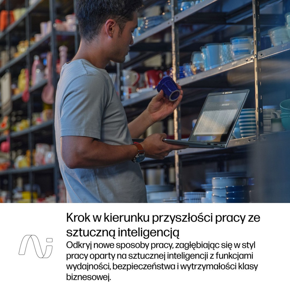 Mężczyzna z laptopem i niebieskim kubkiem na półce magazynowej.
