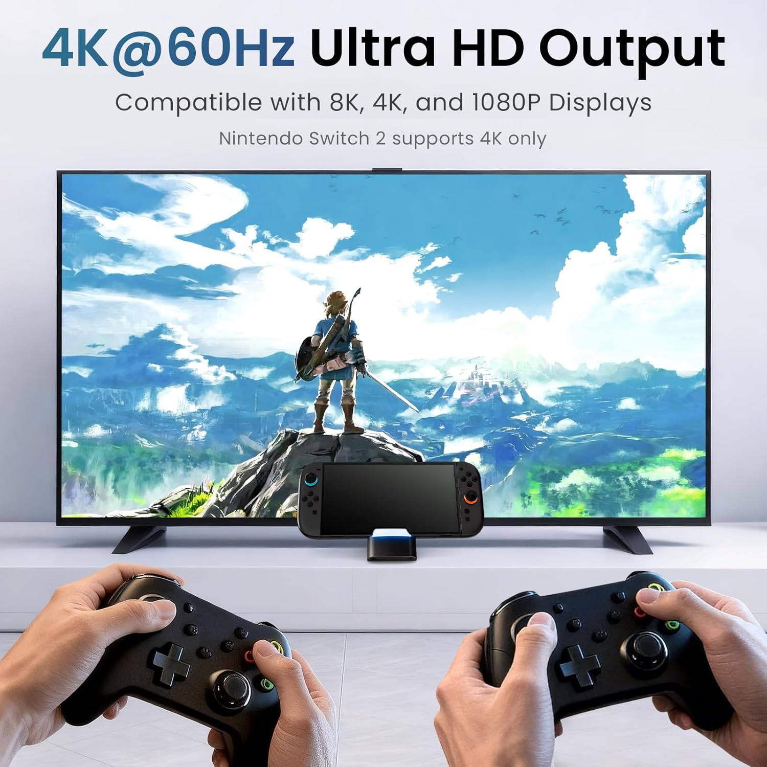 Hände halten Controller und spielen ein Spiel auf einem großen Fernseher mit einer Figur auf einem Berg.