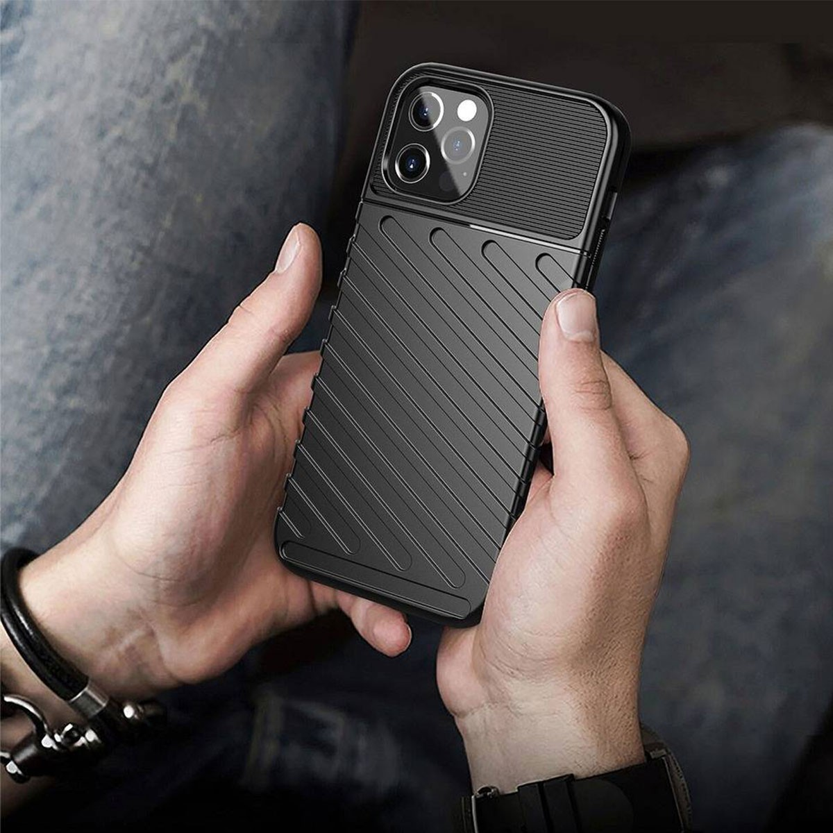 Persona che tiene uno smartphone nero con custodia protettiva.