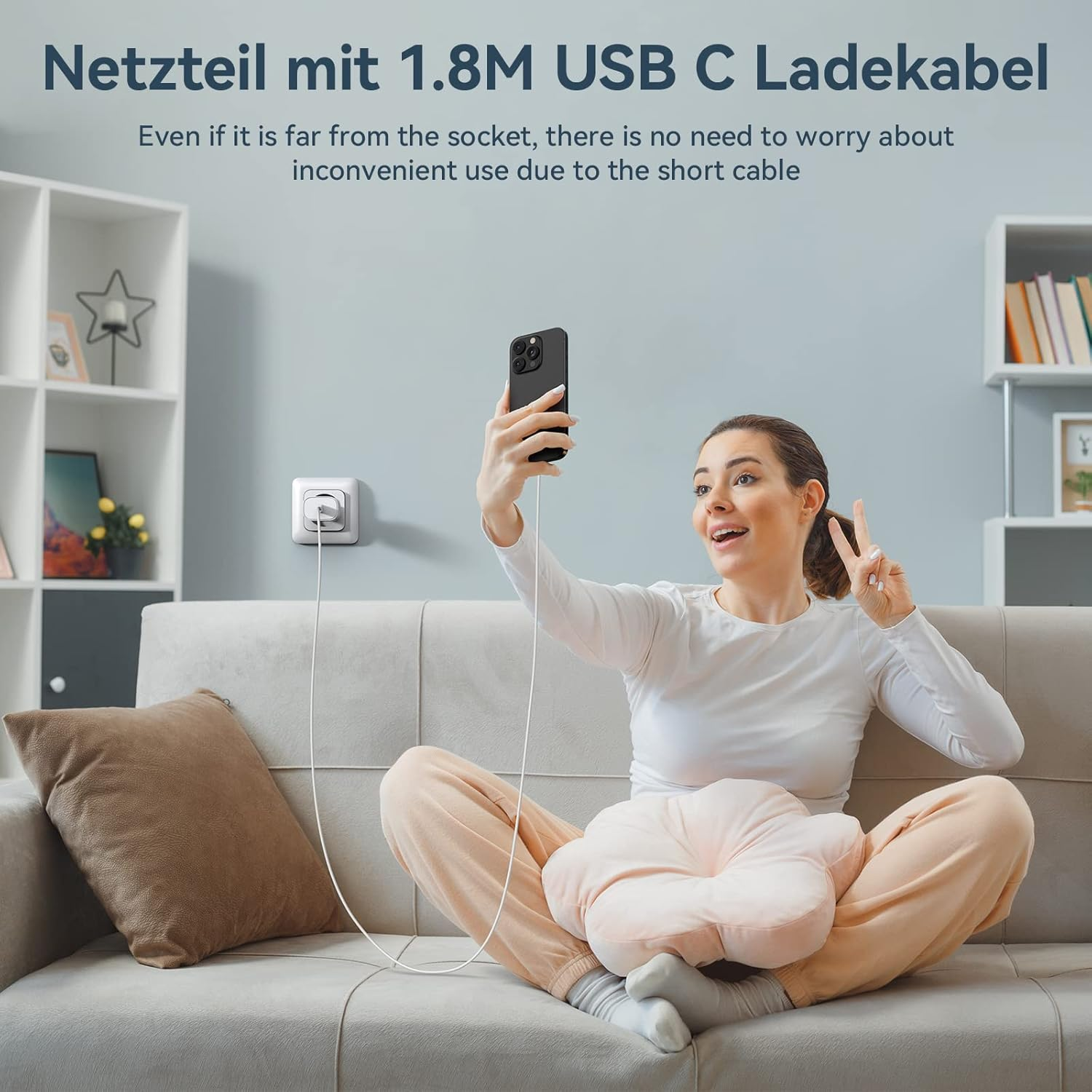 Frau sitzt auf Sofa, nimmt Selfie mit Handy, während es lädt.