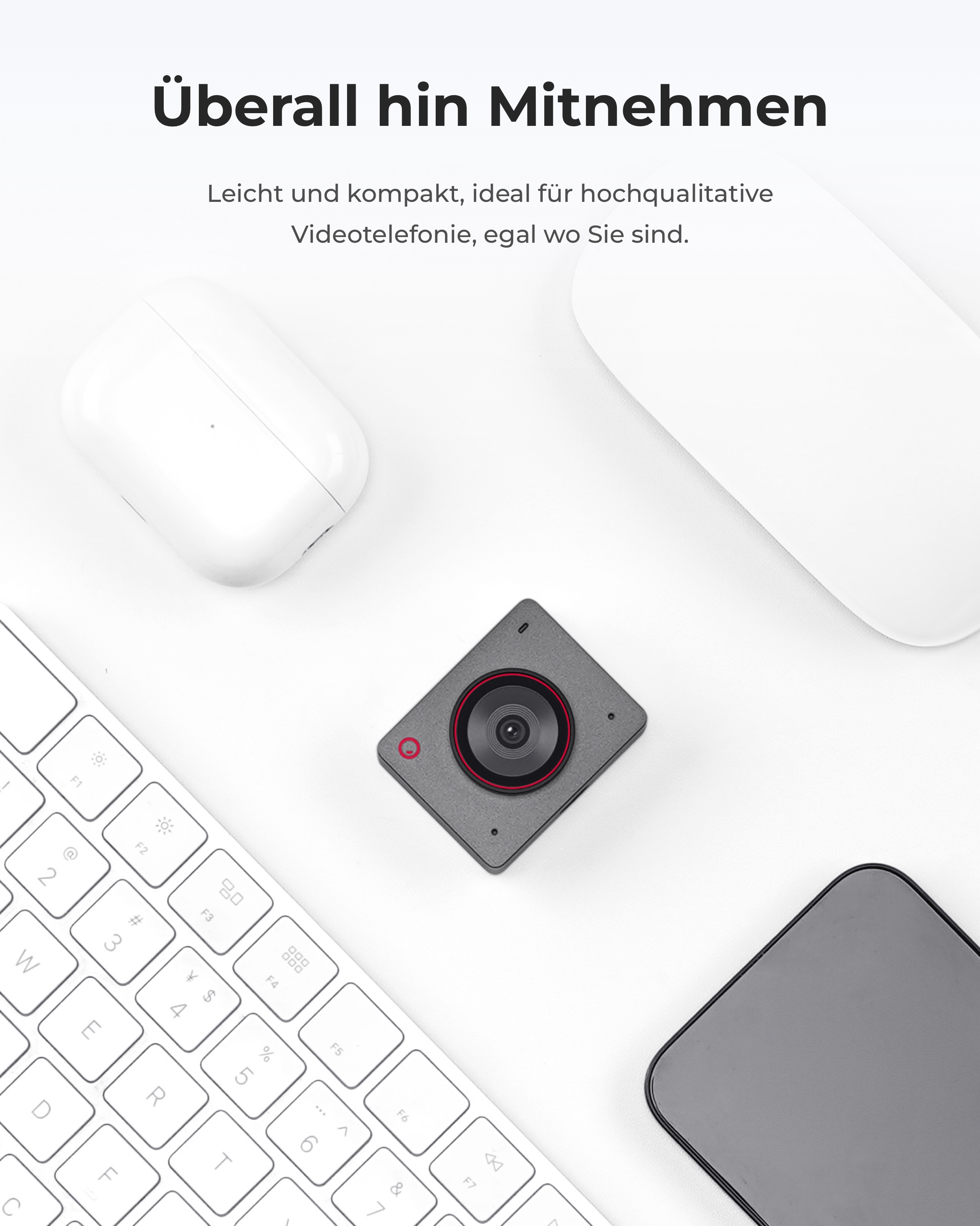Graue Kamera, Tastatur, Maus, Handy und weiße Kopfhörer auf weißem Grund.