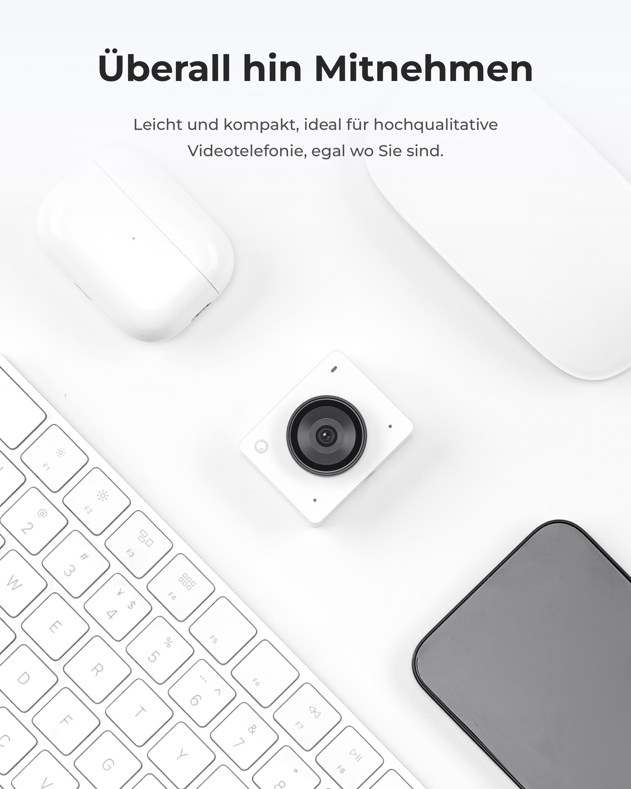 Ein weißes Laptop, eine Kamera, ein Smartphone und ein Ladecase auf einer weißen Fläche.