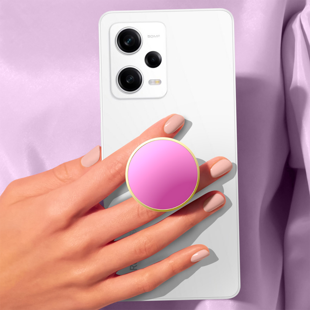 Una mano con uñas rosa claro sostiene un teléfono blanco con un agarre rosa.