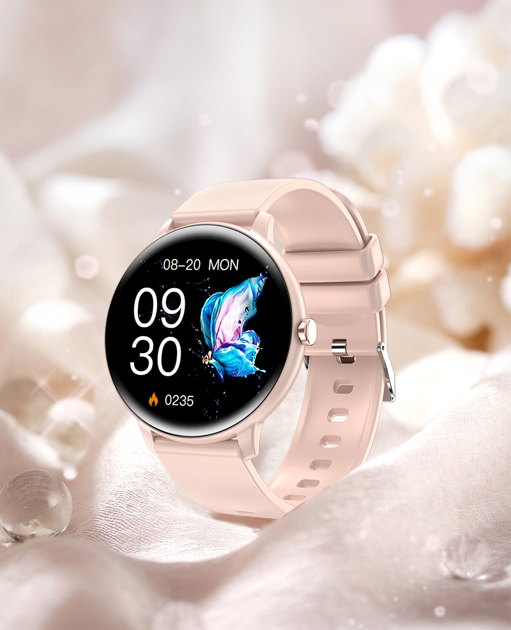 Różowy smartwatch z motylem na ekranie, na miękkiej tkaninie.