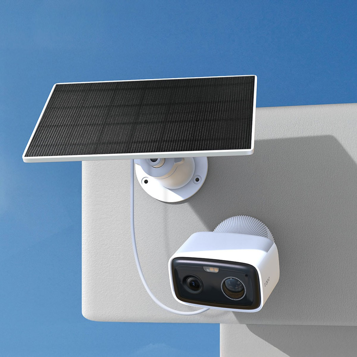 Telecamera di sicurezza bianca con pannello solare montata a parete, cielo blu.