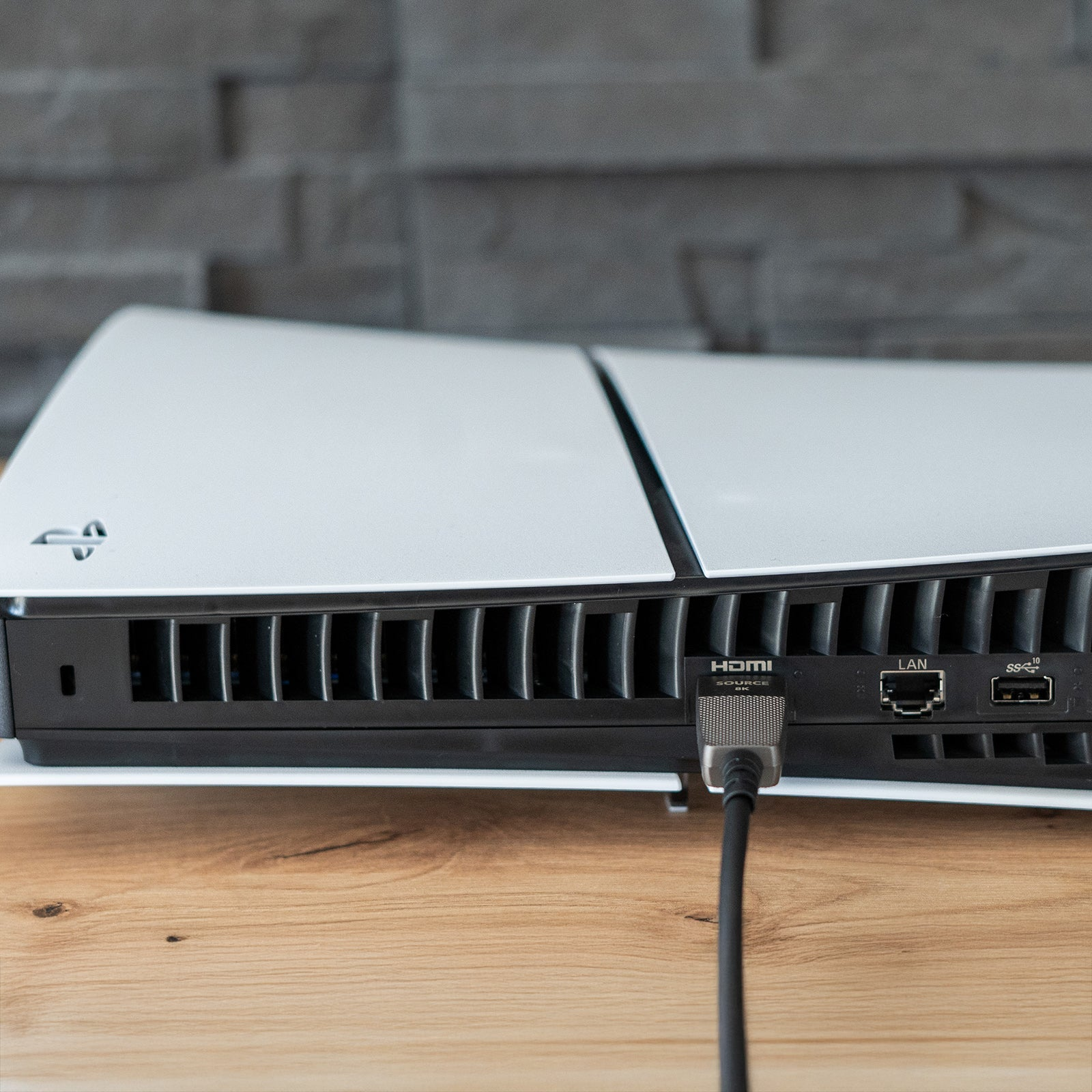 Ein HDMI-Kabel ist an der Rückseite einer weißen Spielkonsole angeschlossen.