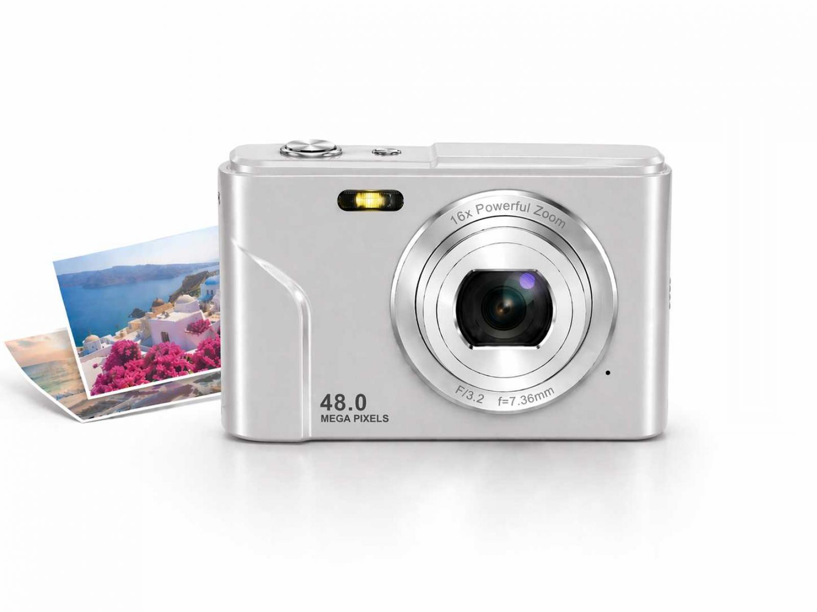 Silberne Digitalkamera mit 16-fachem Zoom und 48 MP. Fotos von Santorini liegen daneben.