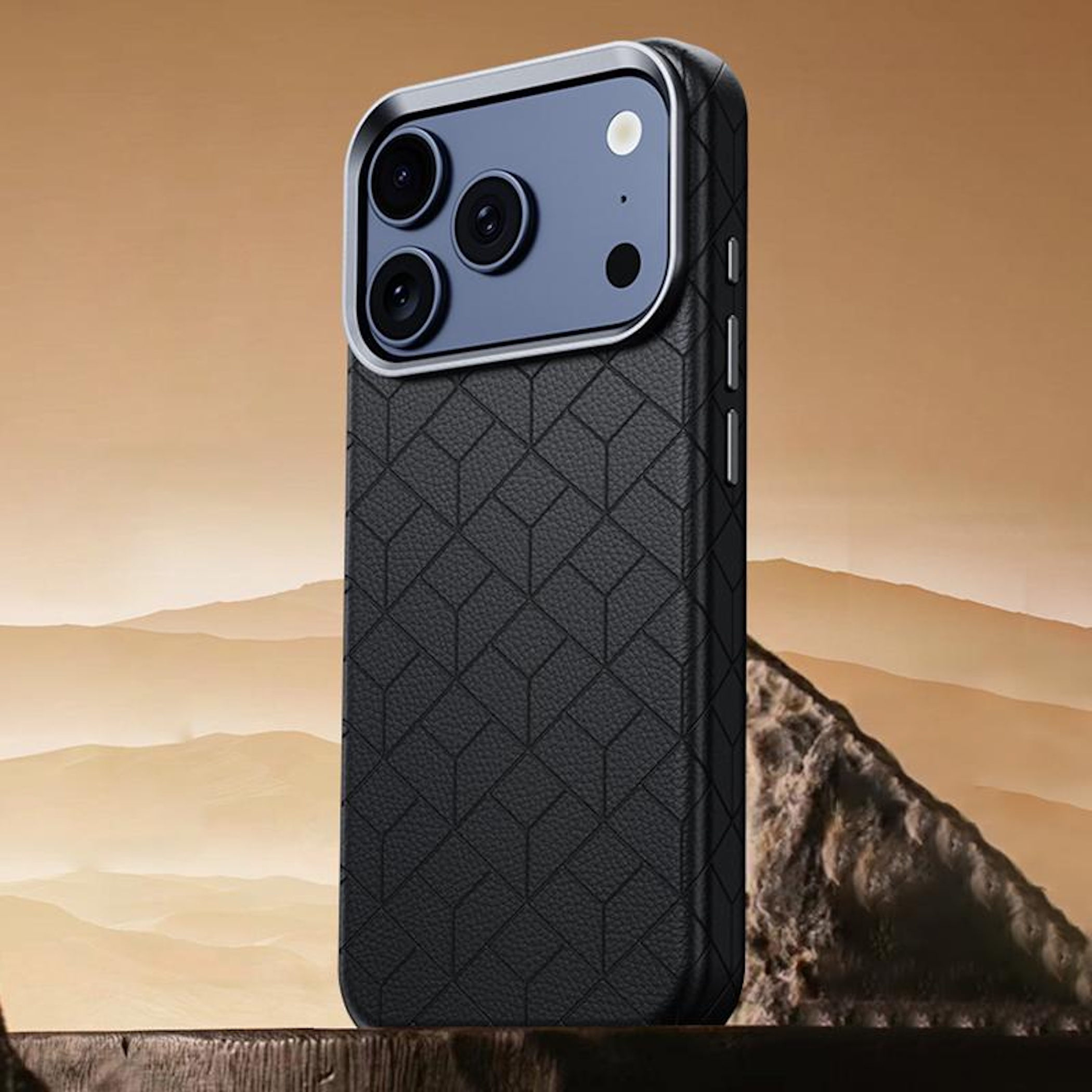 Funda de teléfono negra con patrón de cubo sobre un fondo de paisaje desértico.