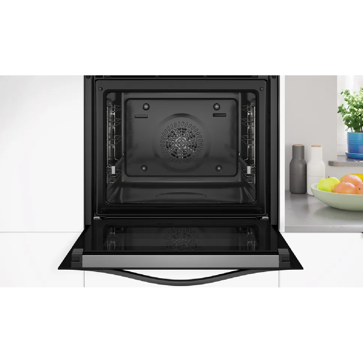 Un forno da incasso moderno con porta aperta, illuminato all'interno.
