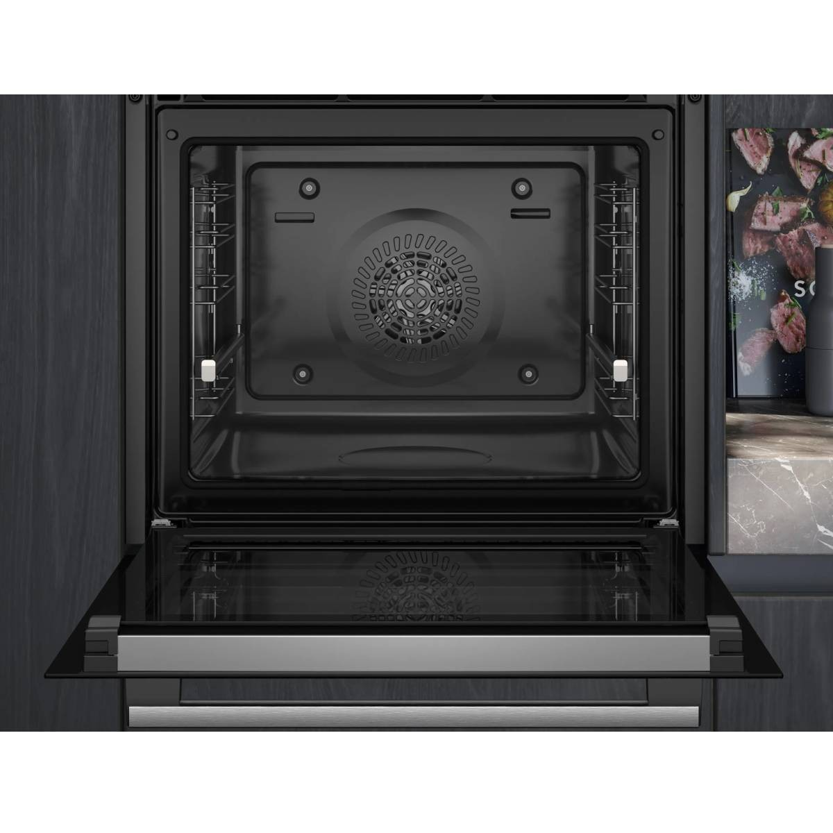 Forno moderno aperto con interno nero e griglia del ventilatore.