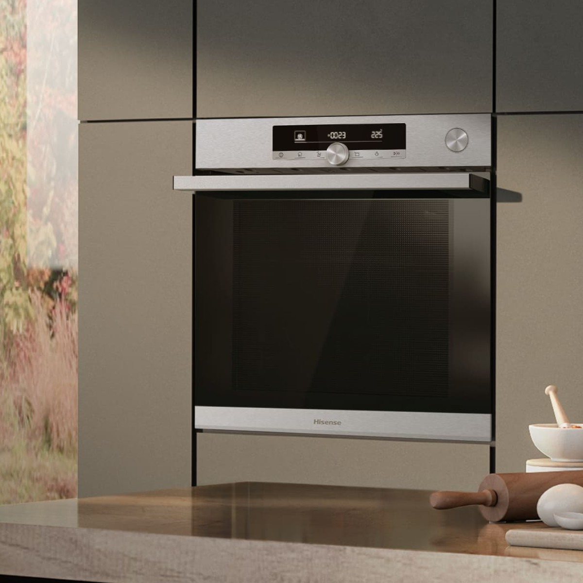 Un moderno forno Hisense in una cucina con piano in legno e vista sull'esterno.