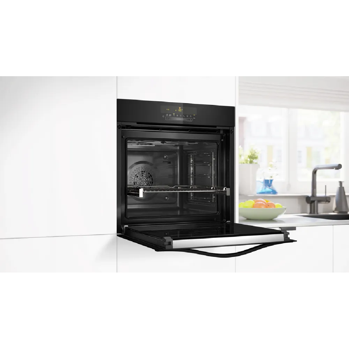 Forno da incasso nero moderno con porta aperta, vista sulla cucina.