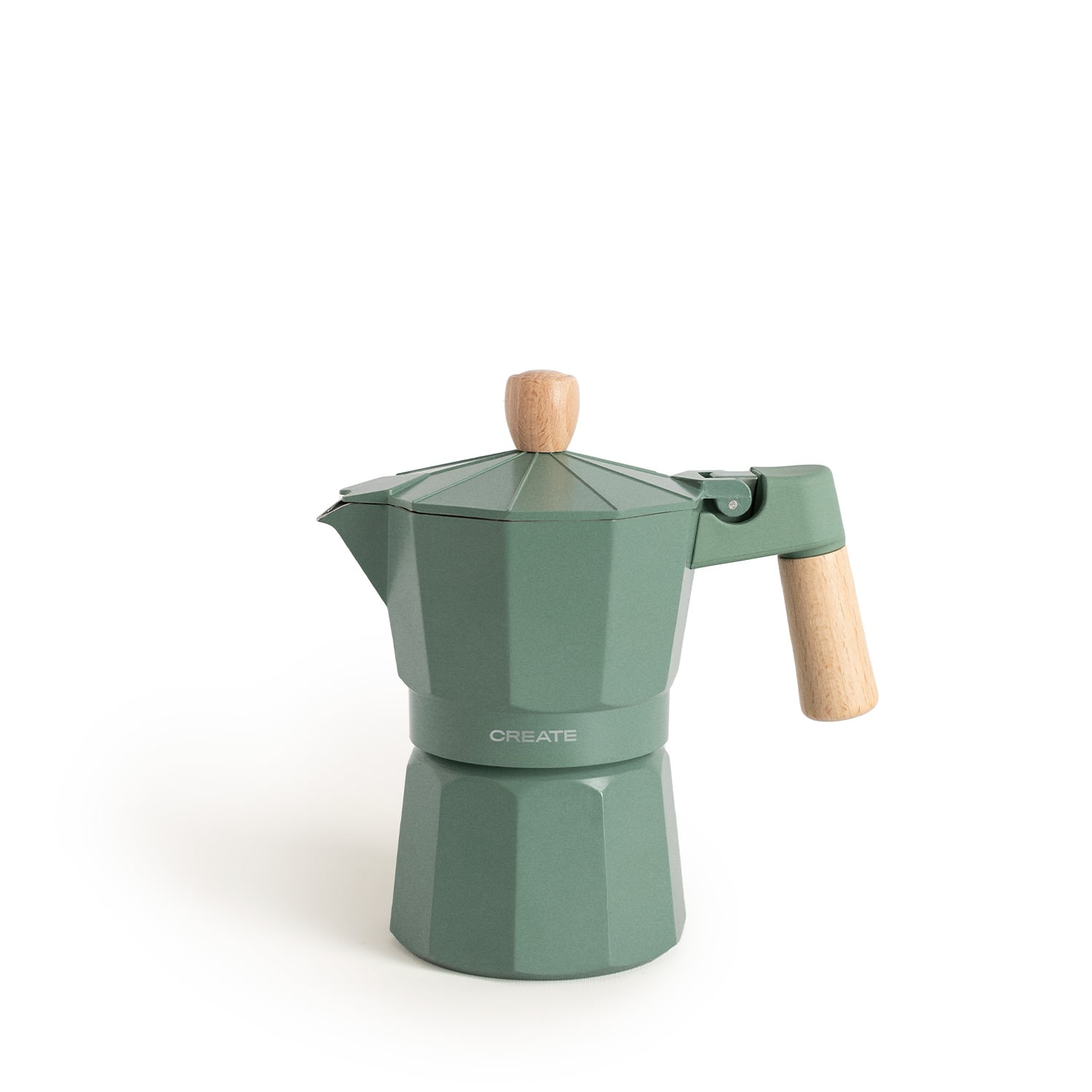 Una cafetera moka verde con mango y pomo de madera se posa sobre superficie blanca.