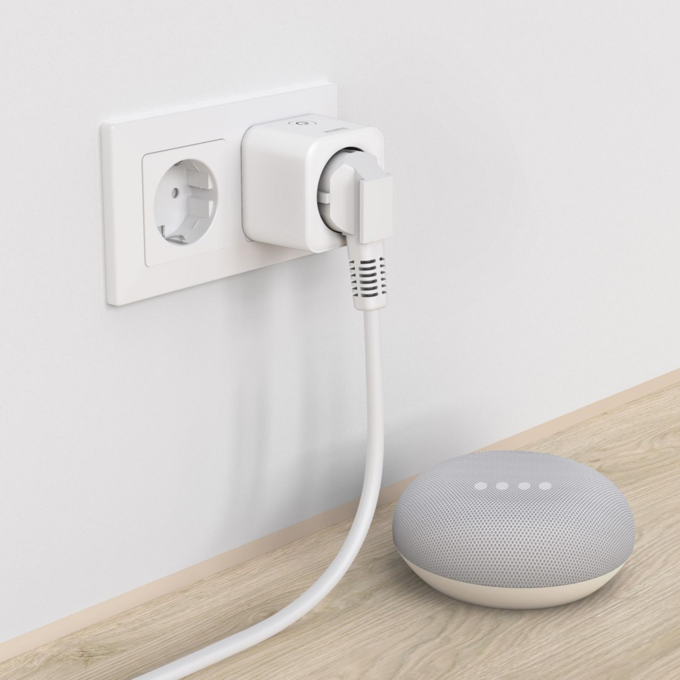 Biała inteligentna wtyczka jest w gniazdku elektrycznym. Kabel prowadzi do małego szarego głośnika.