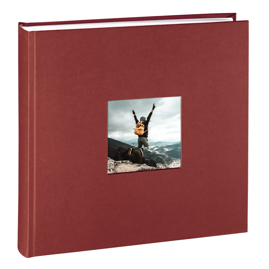 Czerwony album z oknem pokazującym turystę skaczącego w górach.