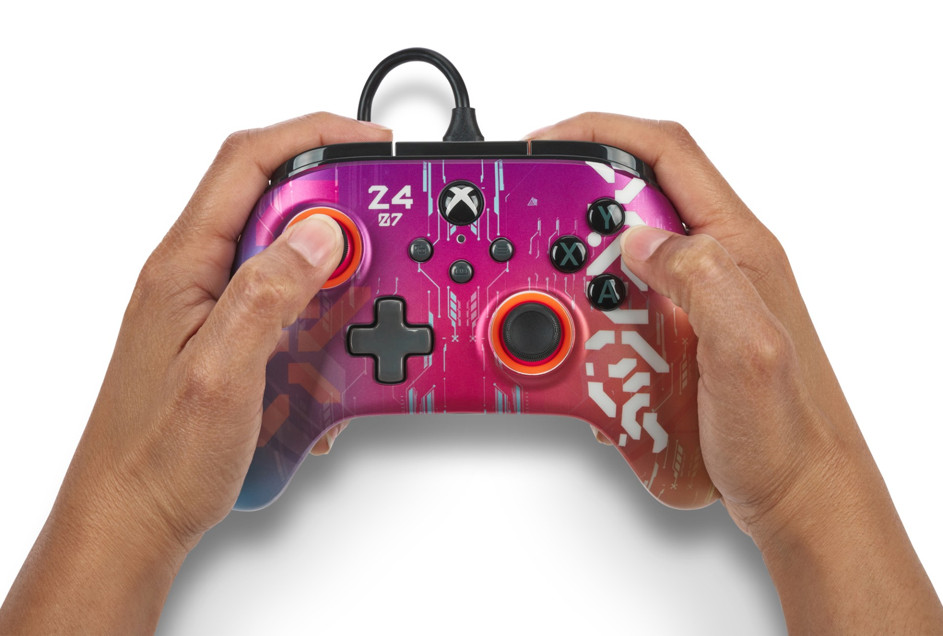 Mani che tengono un controller Xbox rosa-viola con motivo bianco.
