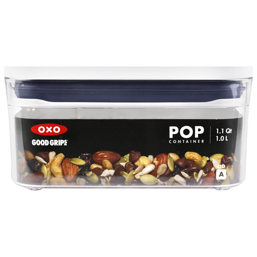 Un contenitore trasparente OXO Good Grips riempito con noci e semi misti.