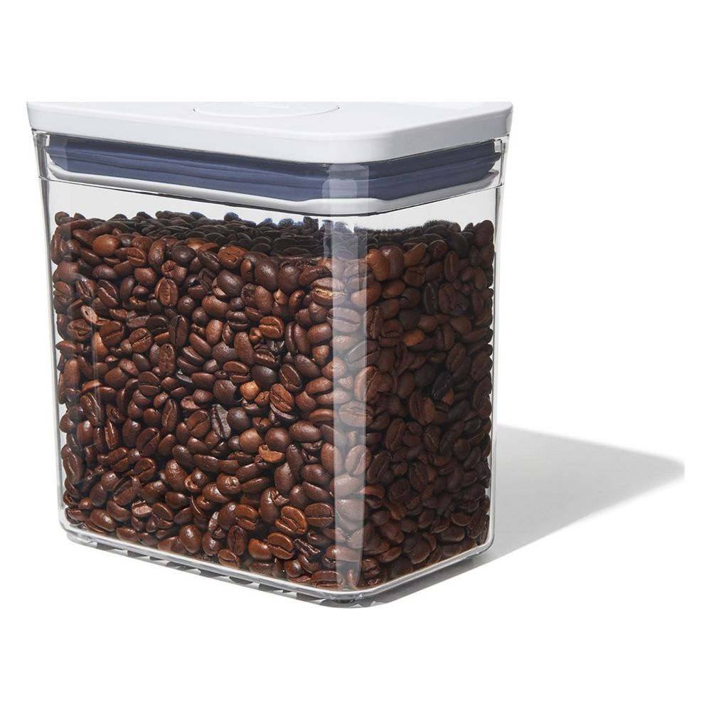 Un contenitore trasparente pieno di chicchi di caffè tostati.
