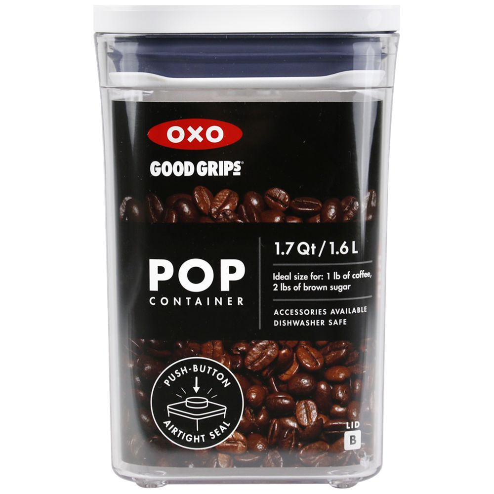 Un contenitore OXO trasparente con coperchio blu, pieno di chicchi di caffè.