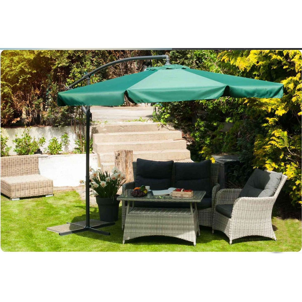 Arredo giardino con ombrellone, tavolo e sedie sull'erba davanti a scale.