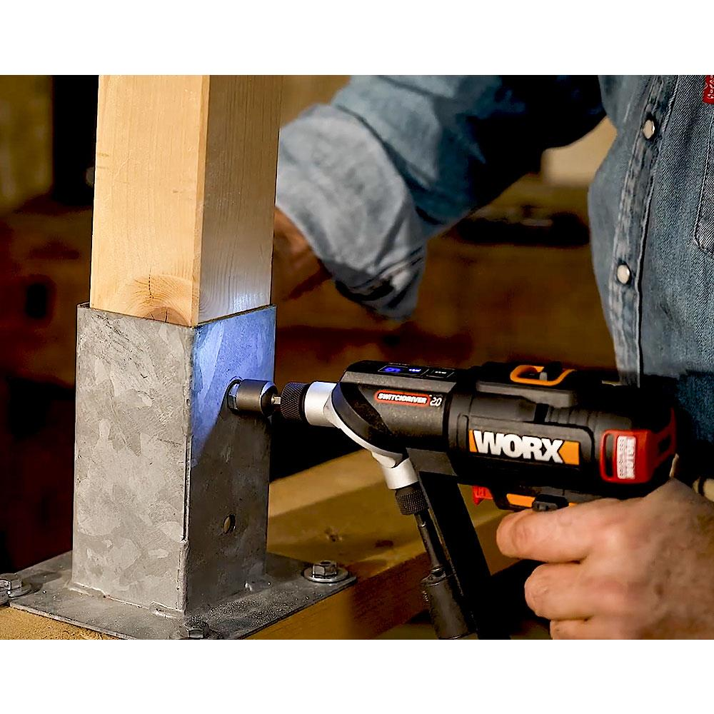 Una persona usa un trapano a batteria per avvitare un palo di legno montato su metallo.