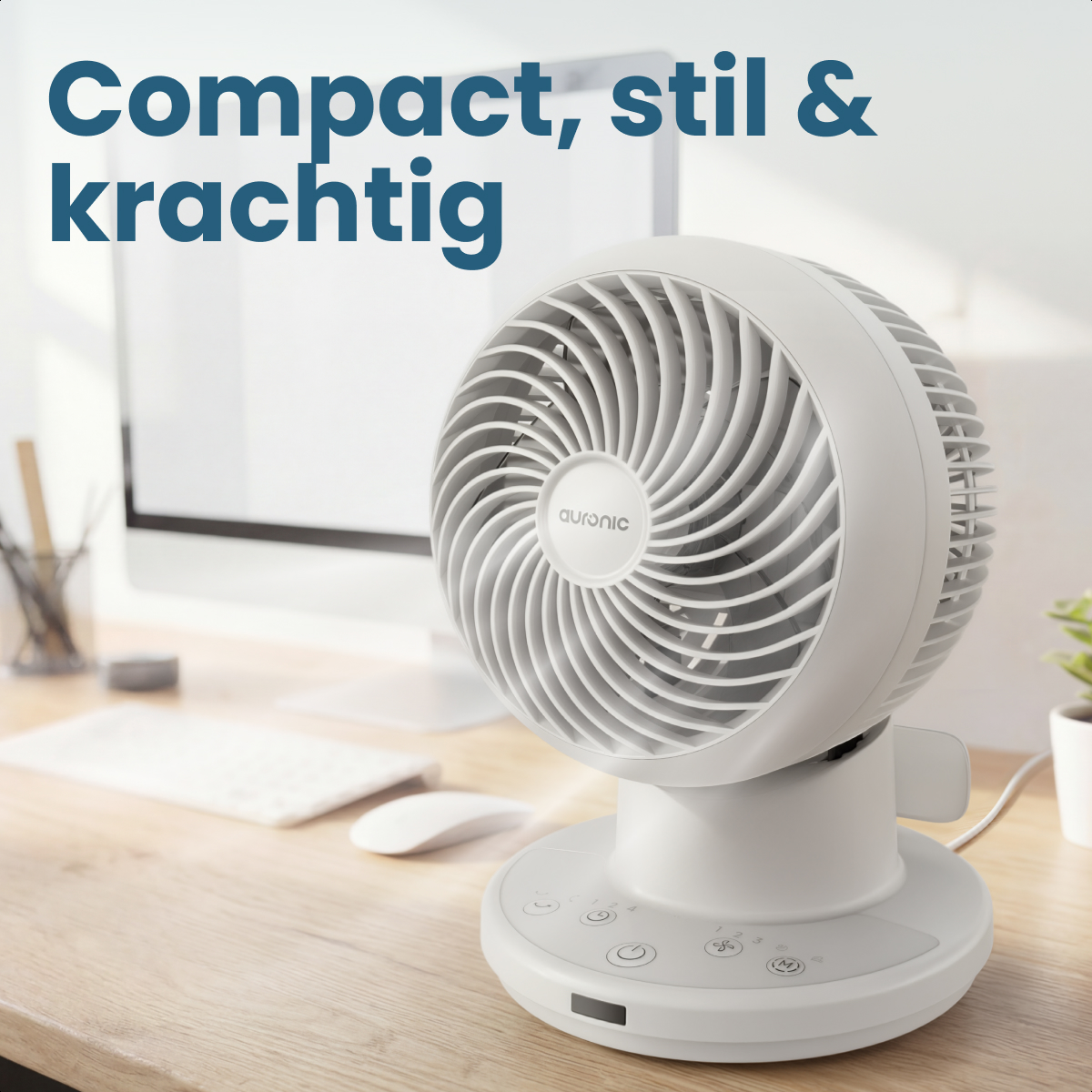 A white desk fan sits on a wooden desk next to a computer.