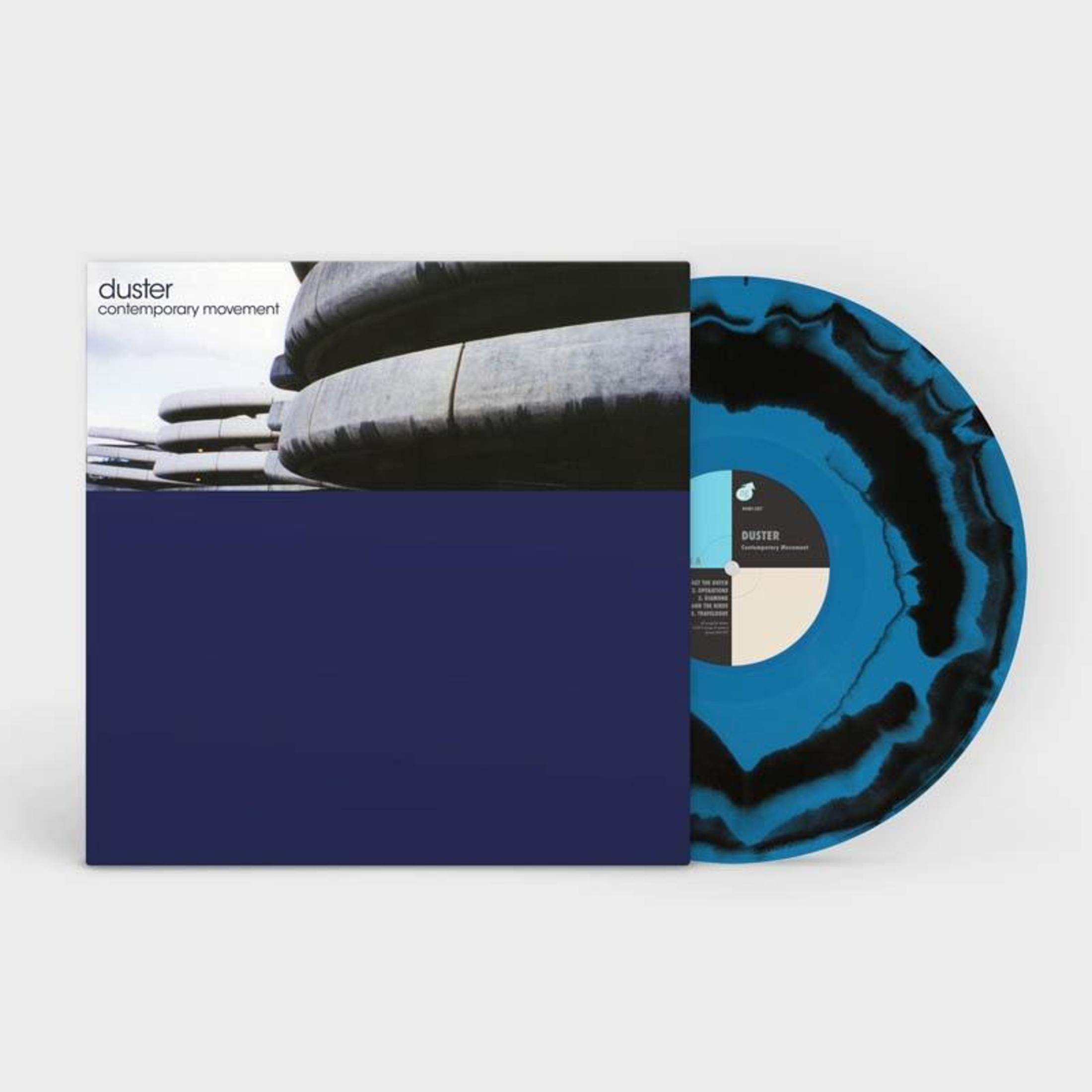 Vinylplaat met blauw en zwart marmerpatroon, hoes met tekst en architectuurfoto.