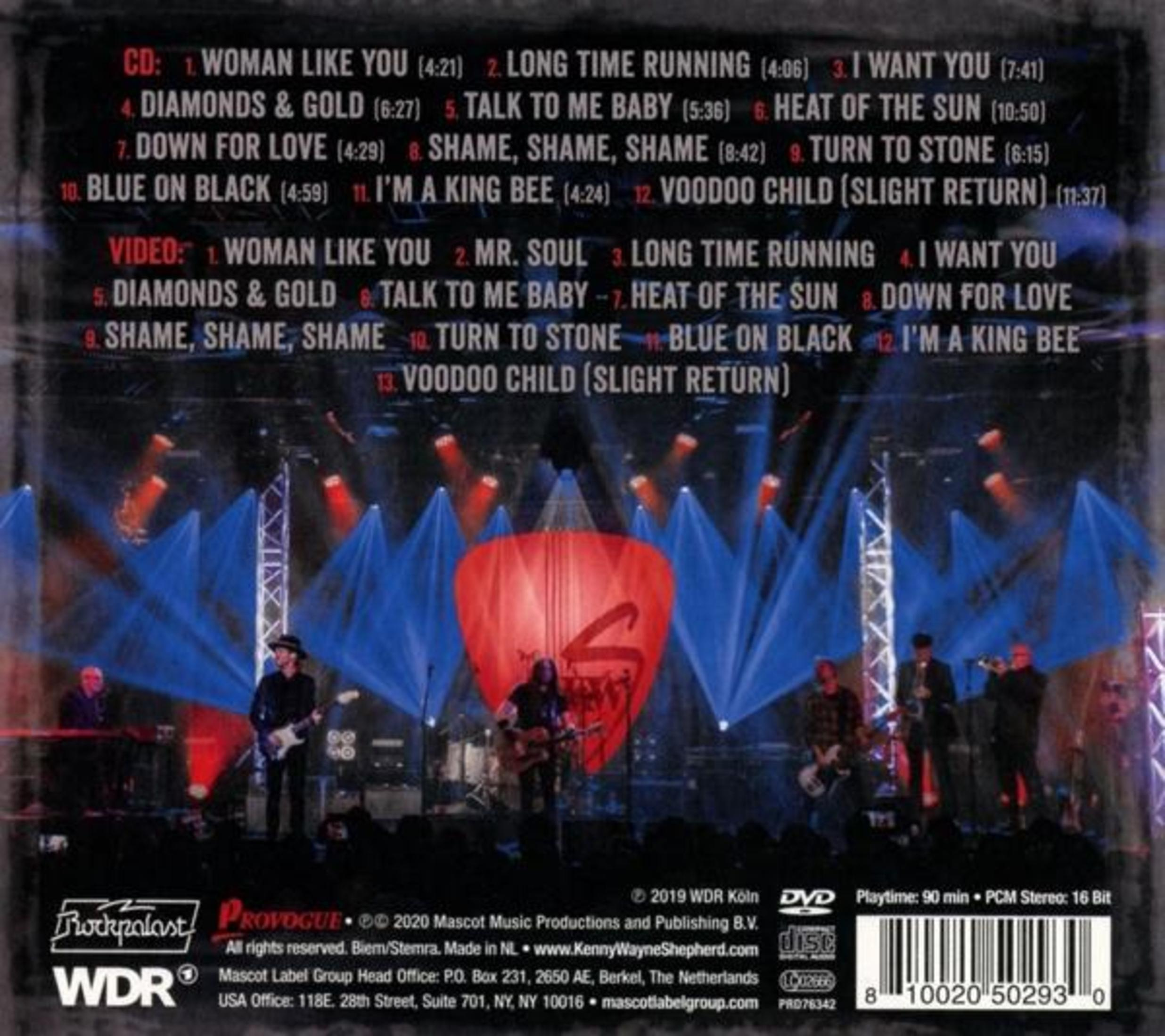 Live band on stage with blue and red lights, tracklist in background.