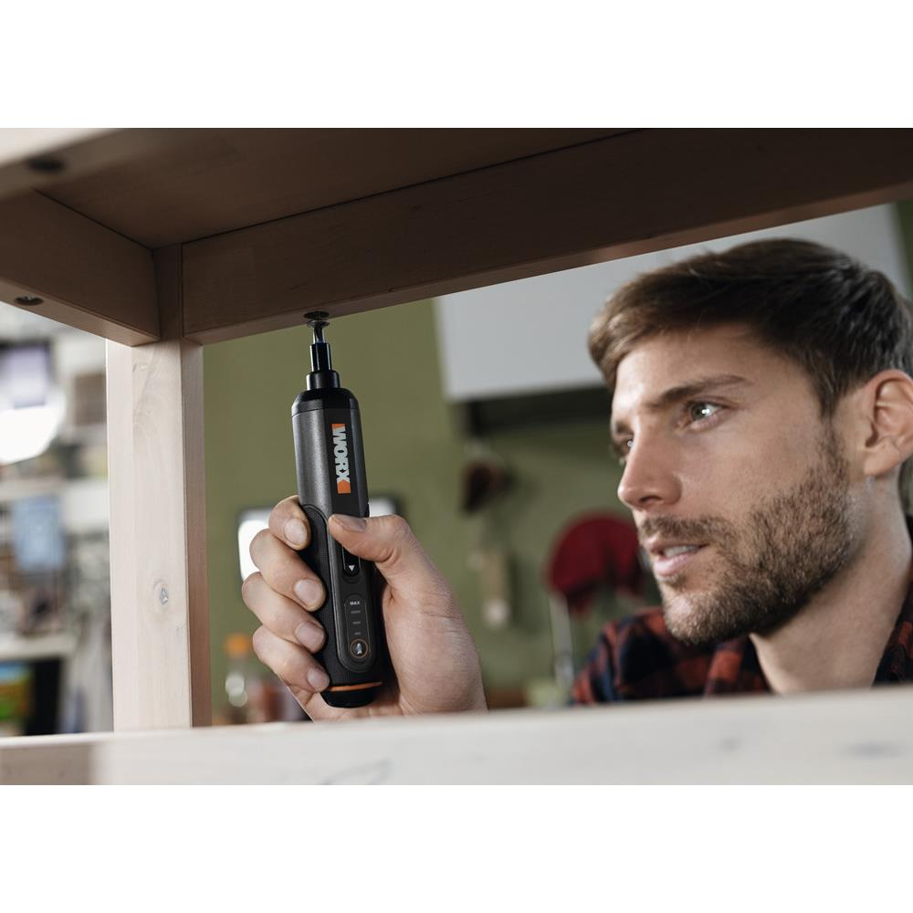 Un uomo usa un cacciavite nero per avvitare una vite nel legno.