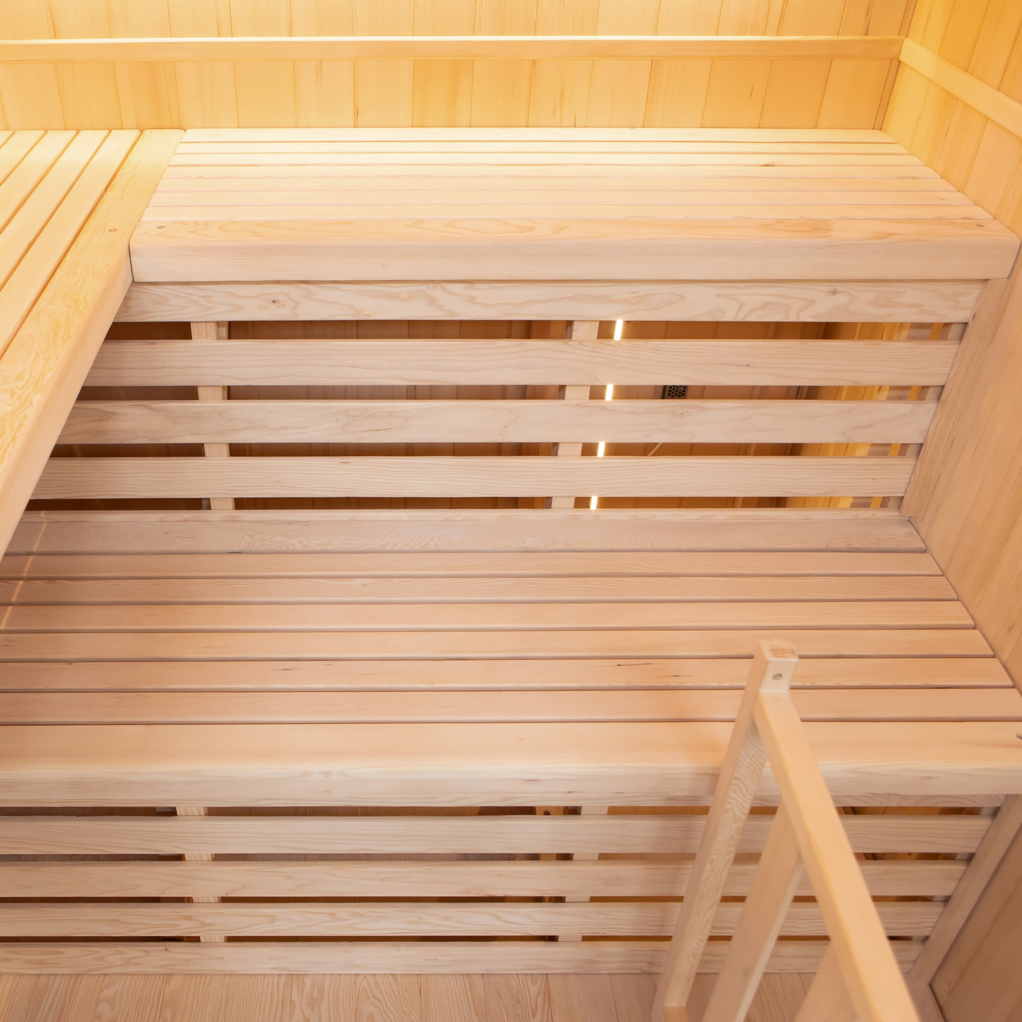 Interior de una sauna con bancos y paredes de madera.