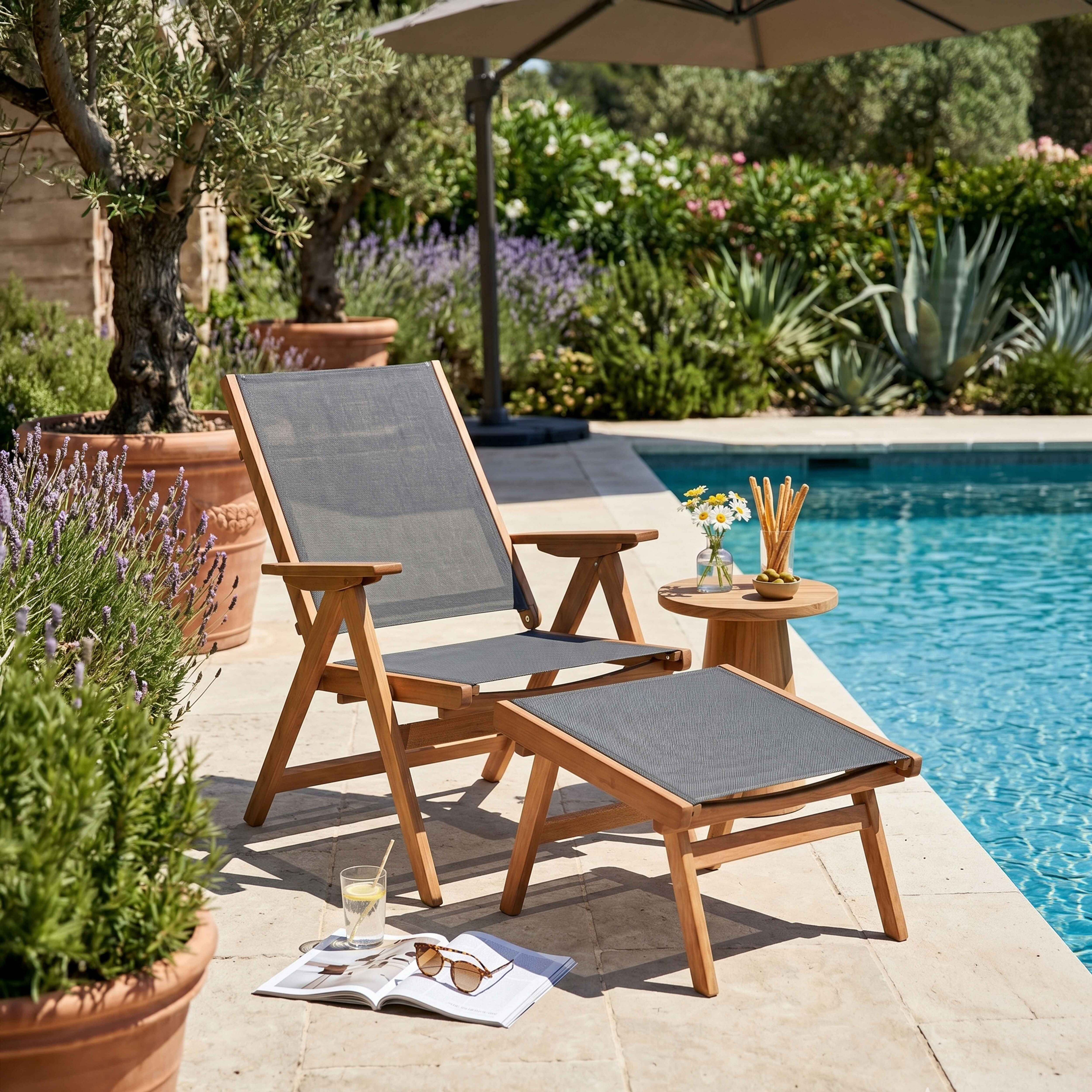 Ein Holzstuhl mit Fußstütze steht neben einem Pool. Ein Tisch mit Snacks und Blumen ist daneben.