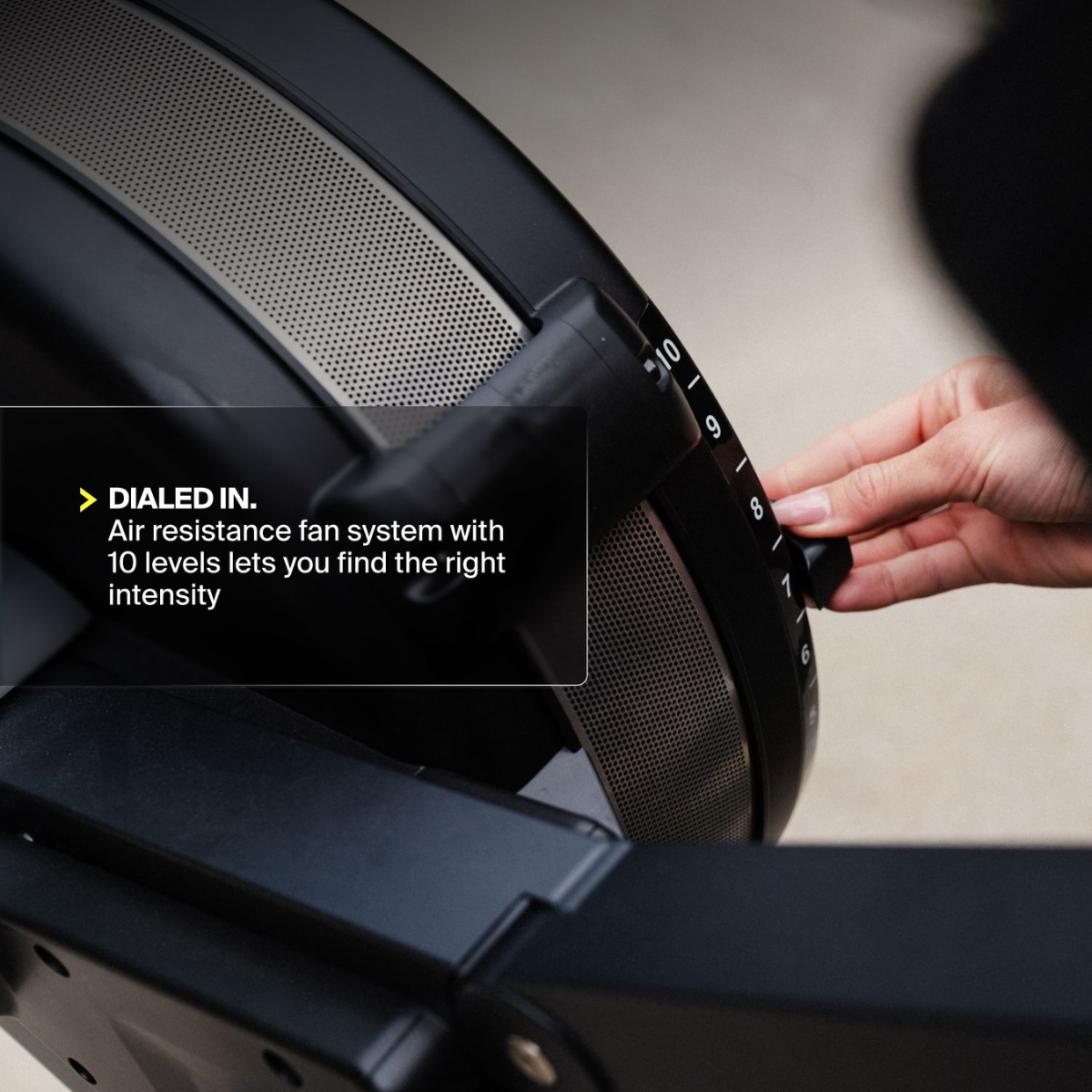 Close up of a hand adjusting a black knob on a fan system with 10 levels.