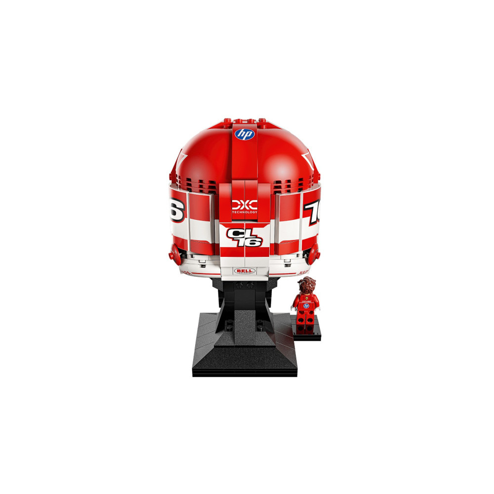 Czerwono-biały kask Lego na czarnym stojaku z małą figurką Lego.