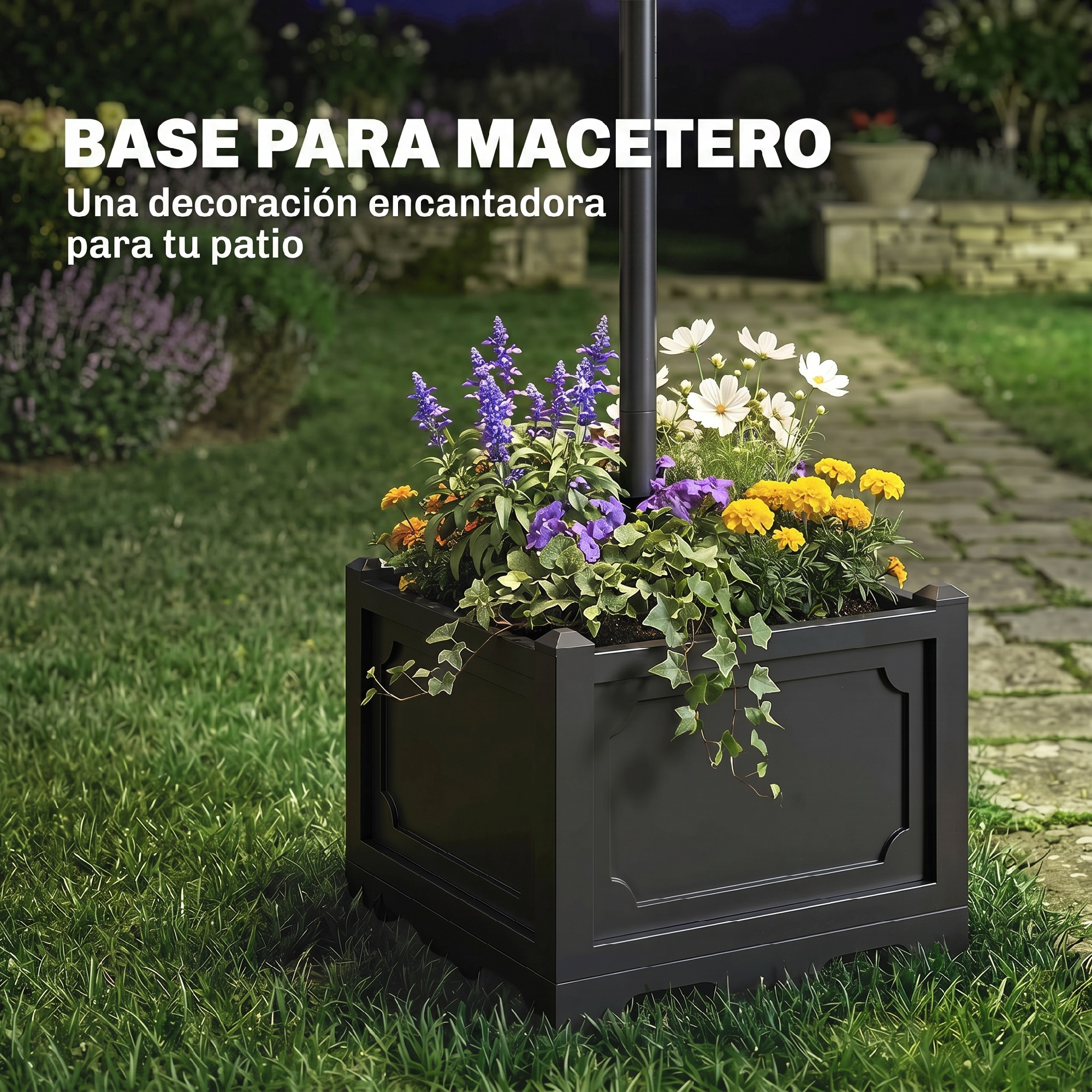 Una jardinera negra con flores coloridas y hiedra verde en un jardín.