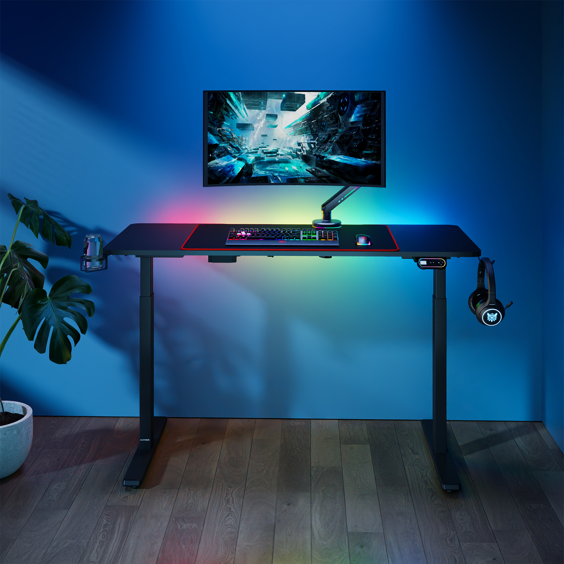 Un escritorio con monitor, teclado, ratón y auriculares, iluminado con luces RGB.