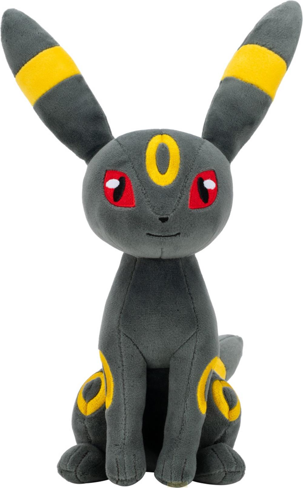 Une peluche Pokémon grise avec des anneaux jaunes et des yeux rouges est assise.