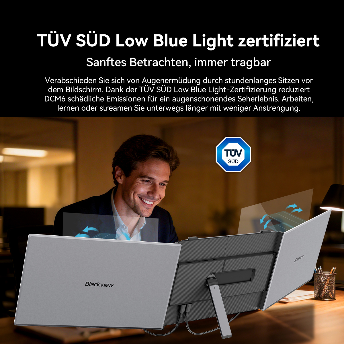 Mann lacht vor Laptop mit TÜV SÜD Low Blue Light Zertifikat.