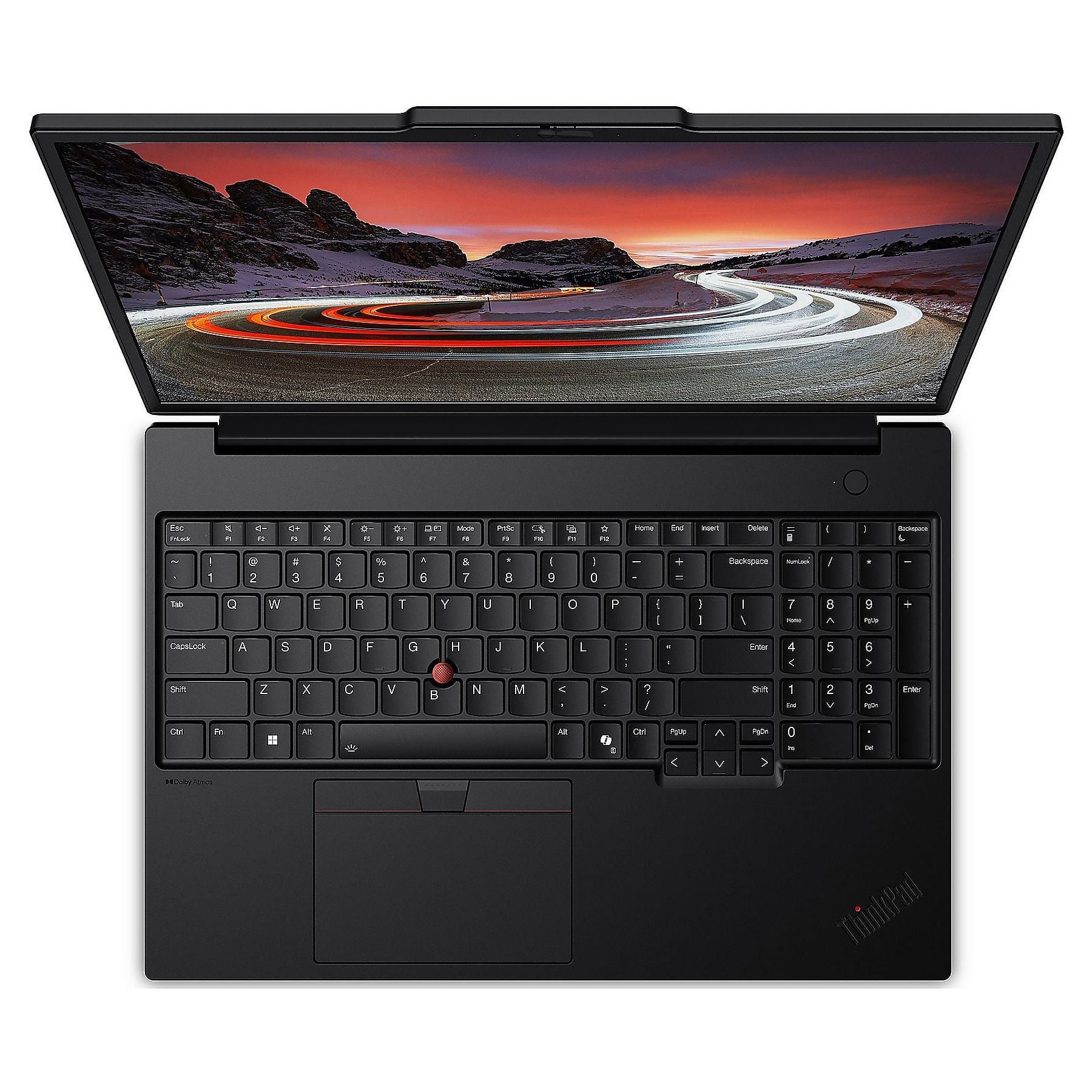 Laptop aperto che mostra una strada con scie luminose in un paesaggio montano al tramonto.