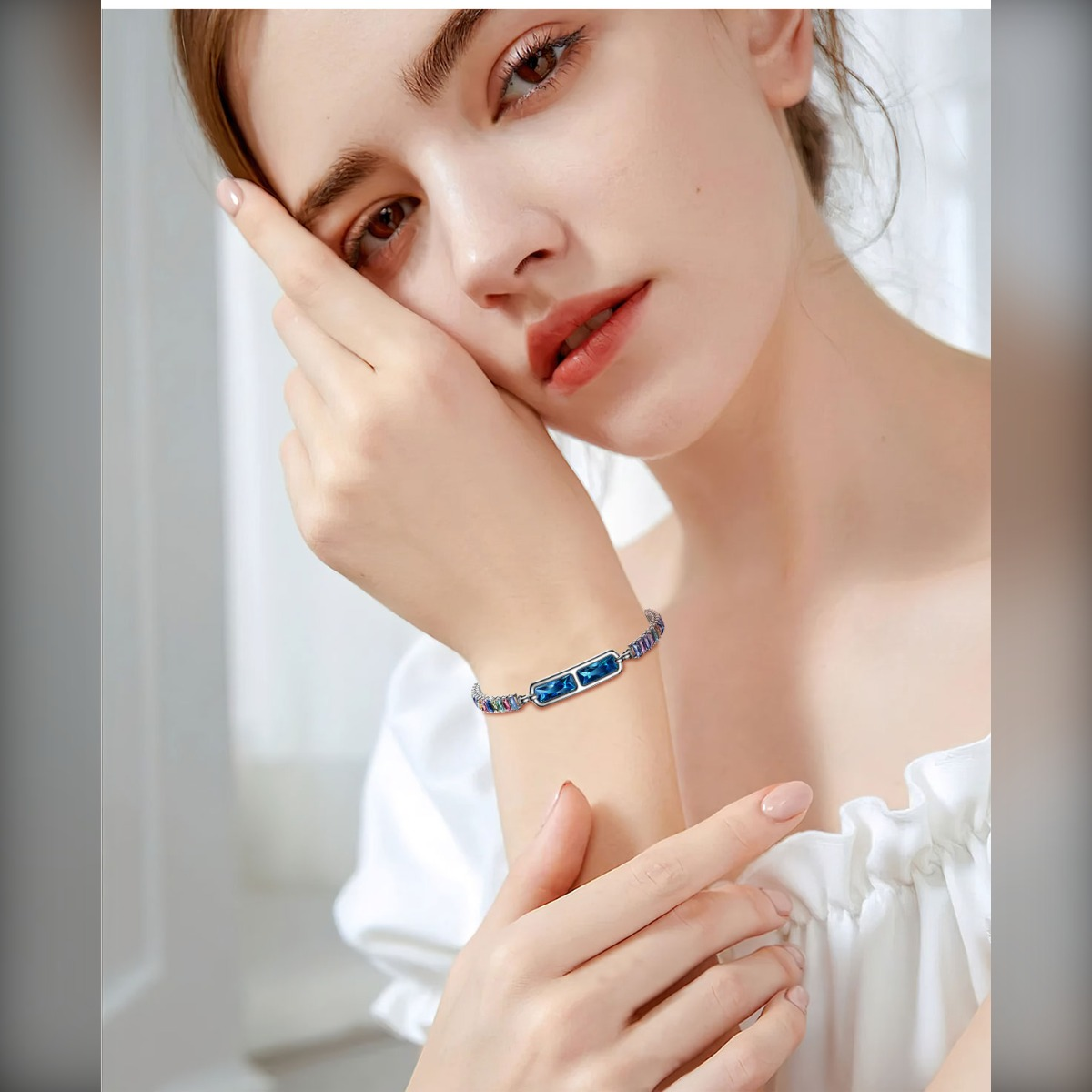 Eine Frau trägt ein blaues Armband mit rechteckigen Steinen.