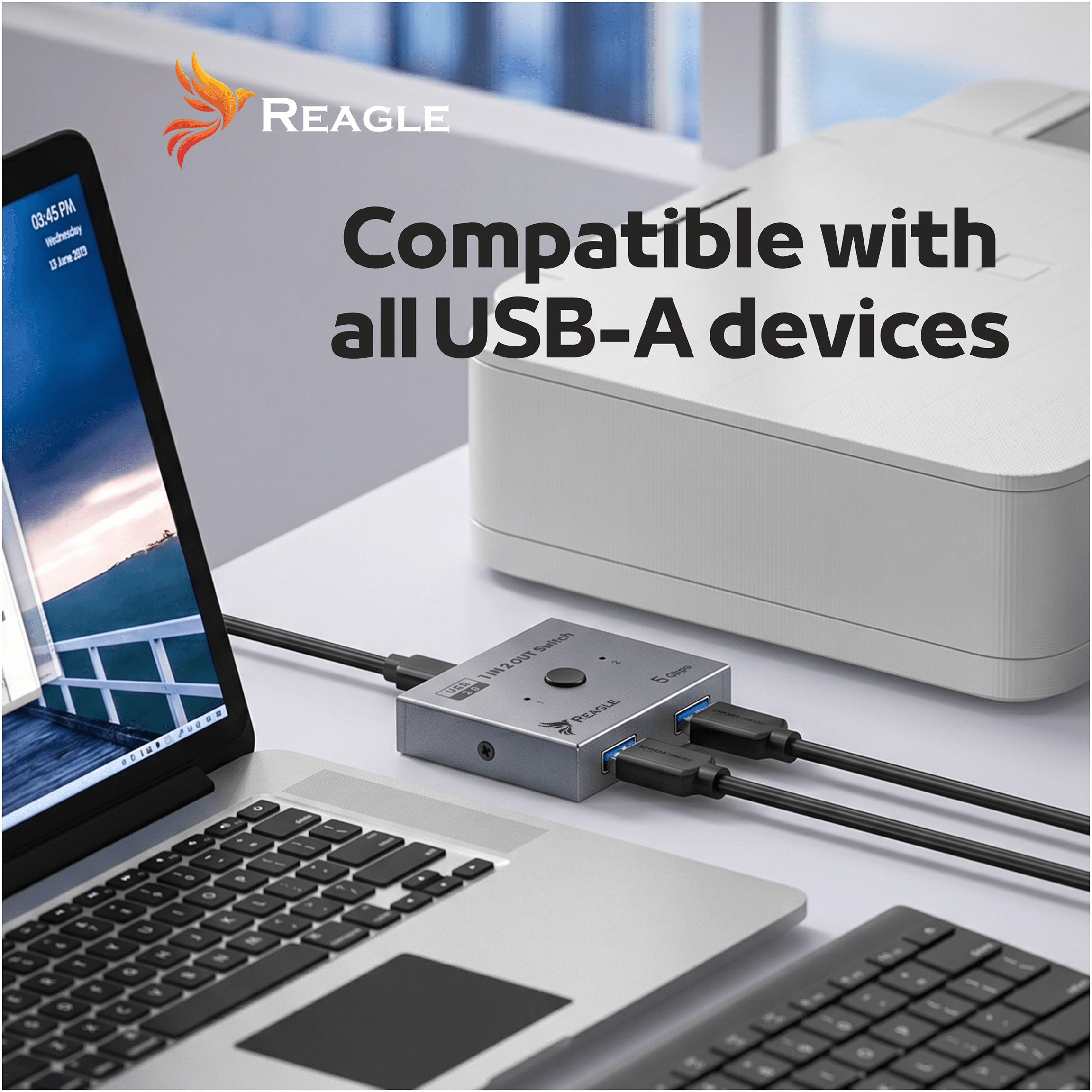 Laptop, przełącznik USB i drukarka na biurku.