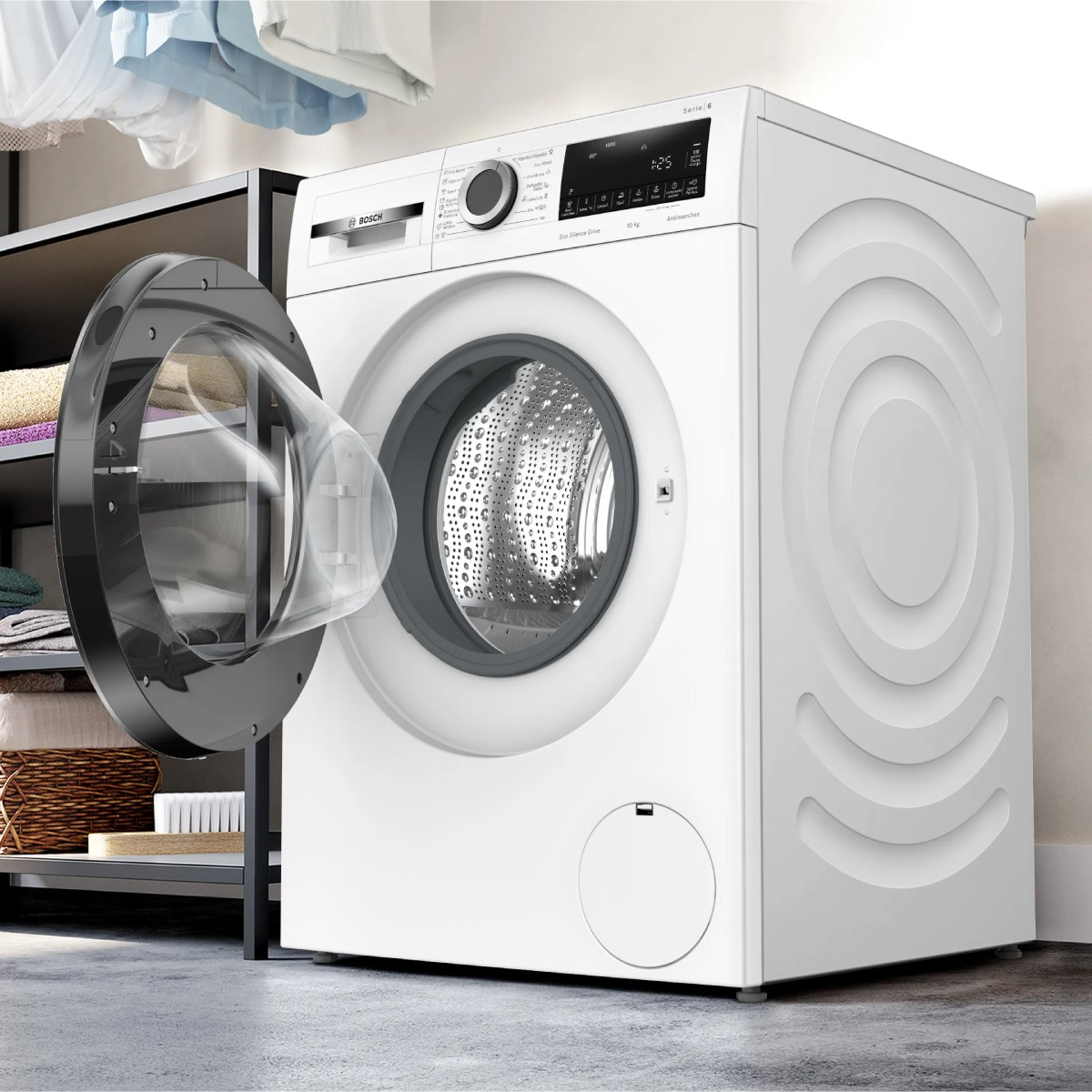Eine weiße Bosch-Waschmaschine mit geöffneter Tür steht neben einem Regal mit Handtüchern.